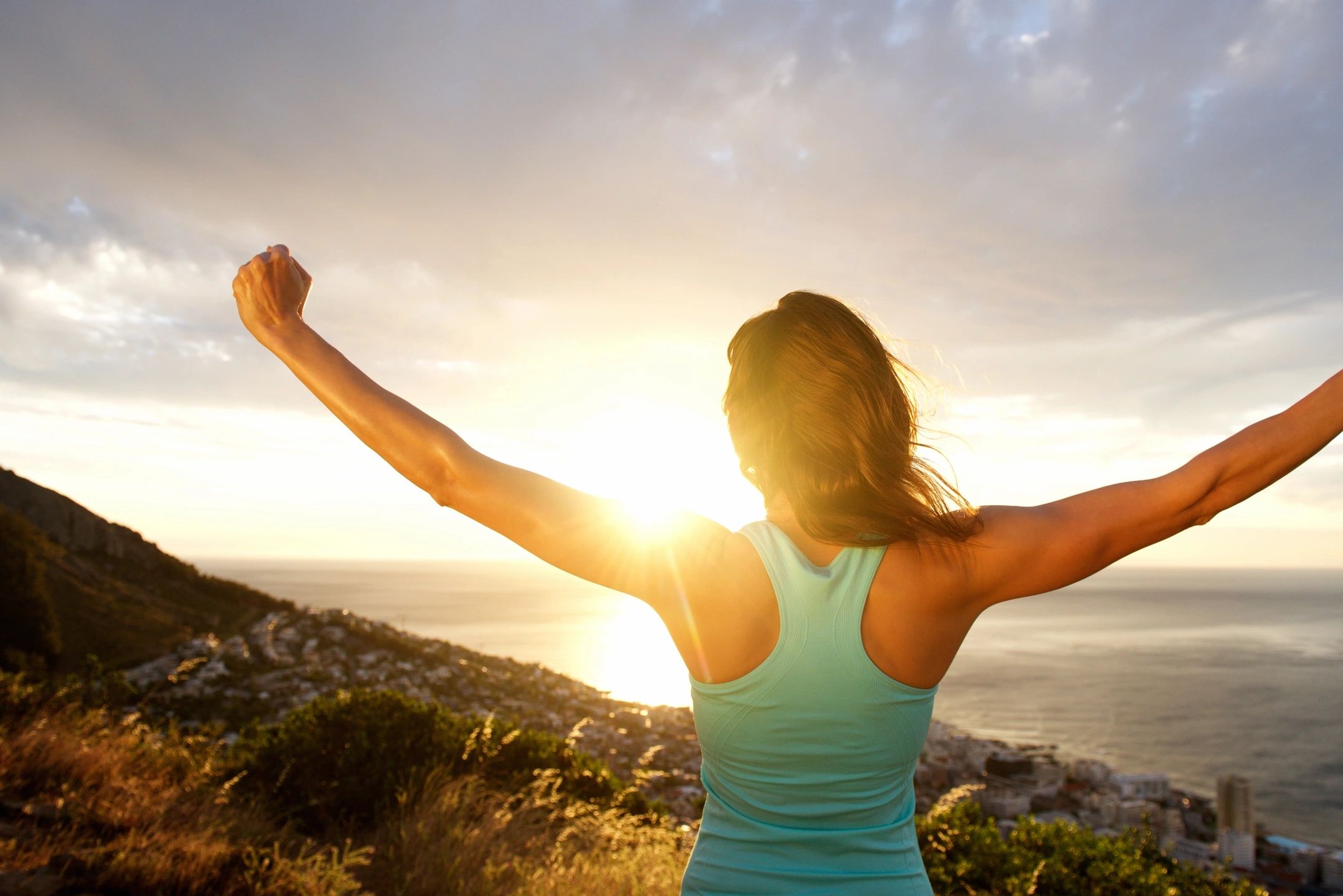 Woman facing landscape at sunset